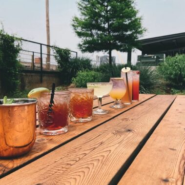 A line of cocktails on a wooden table